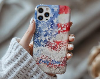 May include: A phone case featuring a watercolor design of the American flag with white stars and stripes. The case has a floral lace overlay and the name "Emily Rose" in blue script.