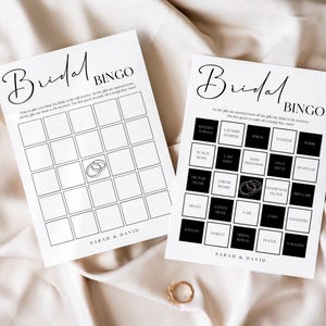 May include: Two printable bridal shower bingo cards. The first card has a simple grid with a ring icon in the center. The second card has a grid with black squares and white squares. The squares have text such as "Kitchen Towels", "Laundry Hamper", "Earrings", "Food Processor", "Champagne Flutes", "Movie Night", "Cash", "Gift Card", "Plates", and "Vases". Both cards have the text "Bridal Bingo" and "Sarah & David" at the bottom.