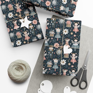May include: Several wrapped gifts with a dark blue floral pattern featuring mice dressed as fairies and nutcrackers. The gifts are tied with twine and have star and heart-shaped tags. A ball of twine, scissors, and blank tags are also present.