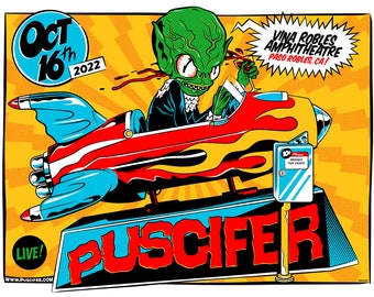 May include: A concert poster for the band Puscifer, featuring a green alien character driving a rocket-shaped car. The poster is yellow with red, blue, and white accents. The text on the poster reads "Oct 16th 2022", "LIVE!", "www.puscifer.com", "Puscifer", and "Vina Robles Amphitheatre, Paso Robles, CA!"