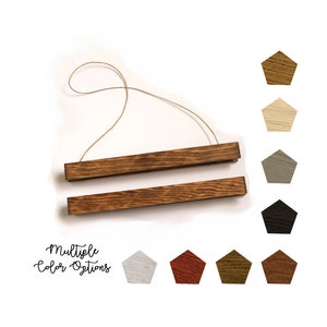 May include: Wooden poster hanger with a dark brown finish, suspended by a natural twine. The image also displays multiple color options in a variety of wood tones, including white, red, and black. Text reads "Multiple Color Options."