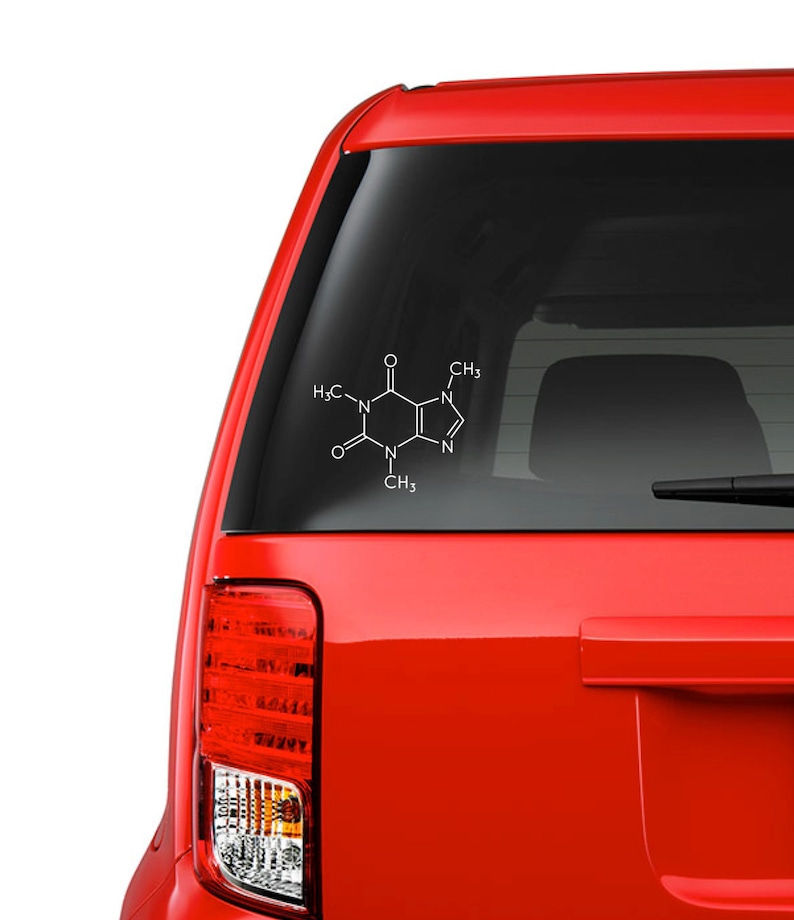 Op de afbeelding: Witte sticker van het cafe&iuml;nemolecuul op de achterruit van een rode auto. De chemische structuur wordt weergegeven in een eenvoudig, strak ontwerp, perfect voor wetenschapsliefhebbers en koffiedrinkers.