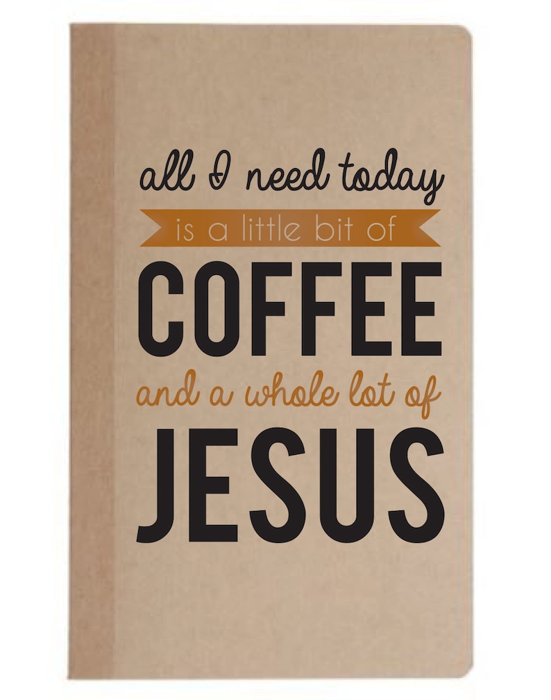 May include: A tan-colored notebook with the text "all I need today is a little bit of COFFEE and a whole lot of JESUS" in black and orange lettering. The notebook has a simple, minimalist design.