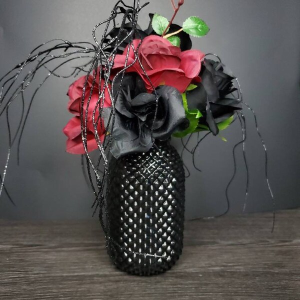 Studded black vase with floral arrangement