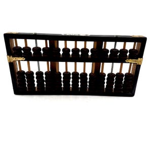 Puede incluir: Un ábaco vintage con cuentas de madera marrón oscuro y un marco negro. El ábaco tiene dos filas de cuentas y esquinas de latón. Una herramienta educativa clásica.