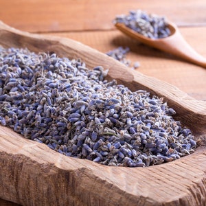 May include: A wooden bowl filled with dried lavender flowers. The bowl is rustic and has a natural wood grain. The lavender flowers are a light purple colour and have a delicate fragrance.