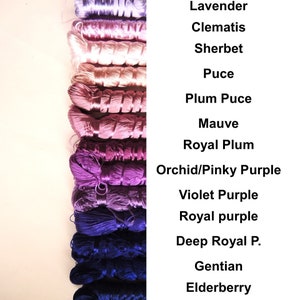 May include: A collection of 12 spools of embroidery floss in shades of purple, pink, and blue. The floss is arranged in order from lightest to darkest, with the names of each color listed to the right. The colors are: Lavender, Clematis, Sherbet, Puce, Plum Puce, Mauve, Royal Plum, Orchid/Pinky Purple, Violet Purple, Royal Purple, Deep Royal P., Gentian, and Elderberry.