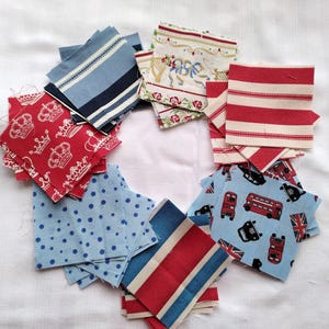 May include: A collection of fabric squares in various patterns and colors, including red, white, blue, and cream. The squares feature designs such as crowns, polka dots, stripes, and a bus pattern.