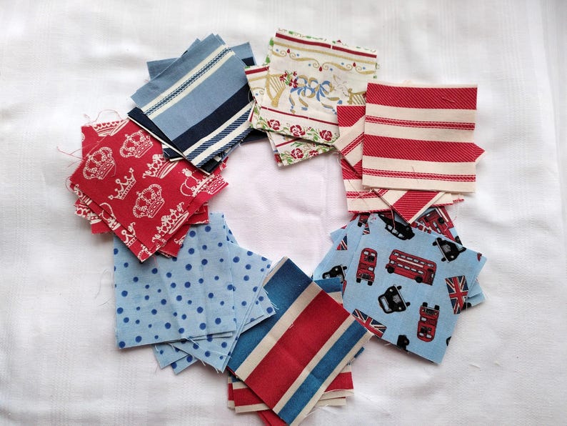 May include: A collection of fabric squares in various patterns and colors, including red, white, blue, and cream. The squares feature designs such as crowns, polka dots, stripes, and a bus pattern.