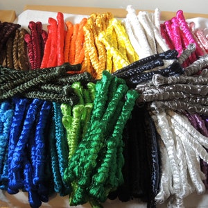 May include: Assortment of colorful embroidery floss spools in various shades of blue, green, red, orange, yellow, brown, black, white, purple, and pink.