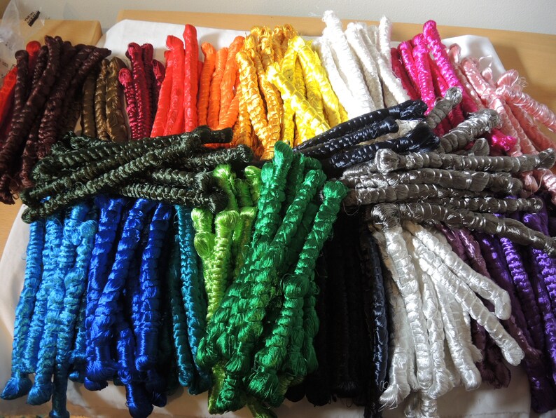 May include: Assortment of colorful embroidery floss spools in various shades of blue, green, red, orange, yellow, brown, black, white, purple, and pink.