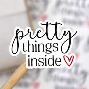 May include: White sticker with black text that reads "pretty things inside" with a small red heart.