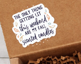 May include: A white sticker with a fall-themed quote on a brown cardboard box. The quote reads "The only thing getting lit this weekend are my fall scented candles".