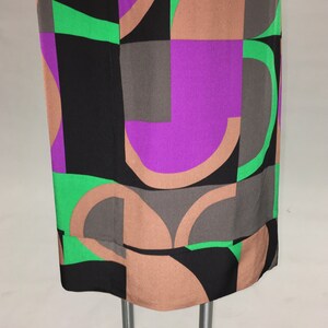 May include: A black, brown, green, and purple geometric print dress with a straight silhouette.