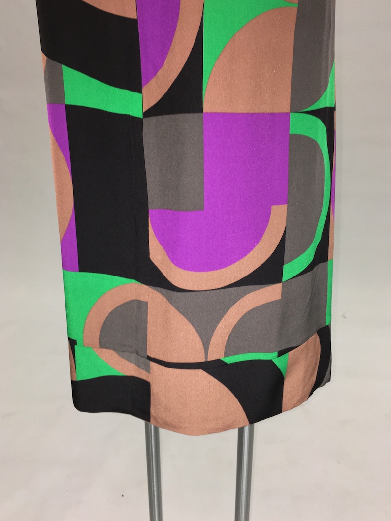 May include: A black, brown, green, and purple geometric print dress with a straight silhouette.