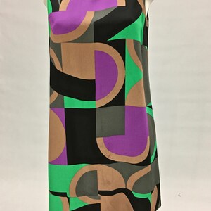 May include: A sleeveless dress with a geometric pattern in shades of brown, green, purple, and black.