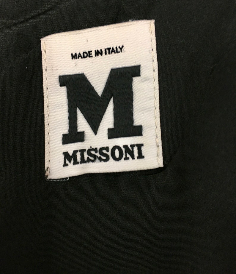 May include: White label with black text that reads "Made in Italy" and "Missoni" with a large black "M" in between the text.