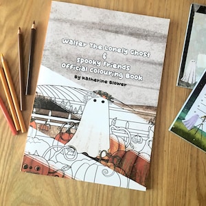 May include: A colouring book titled "Walter The Lonely Ghost & Spooky Friends Official Colouring Book" by Katherine Blower. The cover shows a white ghost character surrounded by pumpkins. Several coloured pencils are visible.