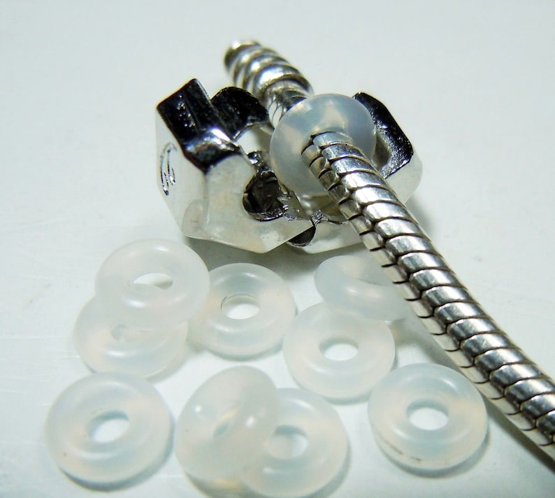 May include: A silver snake chain bracelet with a silver clasp and clear silicone spacer beads.