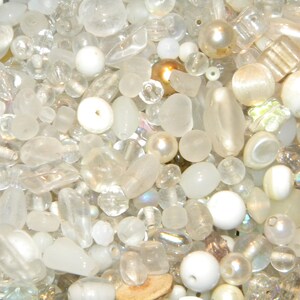 Peut inclure: Un grand assortiment de perles de verre blanches et transparentes, certaines avec des finitions iris&eacute;es. Les perles sont de formes et de tailles vari&eacute;es, notamment rondes, ovales et en forme de larme.