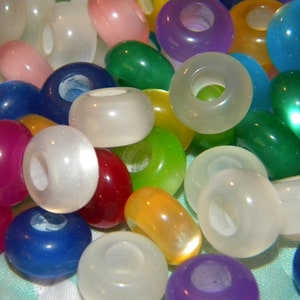 May include: A collection of round, smooth, translucent beads in a variety of vibrant colors including white, blue, green, yellow, red, purple, and pink. Each bead features a central hole, creating a uniform shape across the assortment.