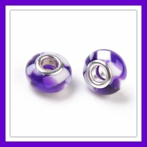 May include: Two purple and white glass beads with silver metal accents. The beads have a swirl pattern and are designed to fit on a charm bracelet.