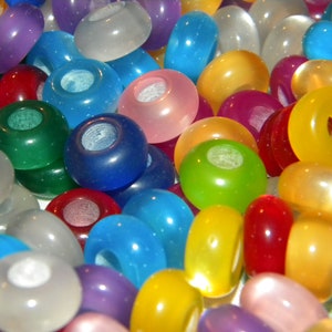 May include: A collection of round, translucent beads in a variety of vibrant colors including blue, green, yellow, red, purple, pink, and white. Each bead features a smooth, polished finish and a central hole, creating a colorful assortment.
