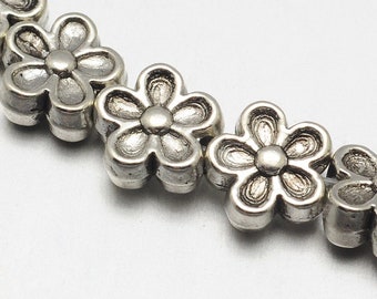 May include: A silver chain of flower-shaped beads. Each bead has a raised, textured design.