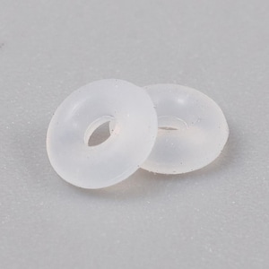 May include: Two translucent, white, rubber O-rings. The O-rings are circular with a hole in the center. The O-rings are made of a soft, flexible material. The O-rings are likely used for sealing or as a gasket.
