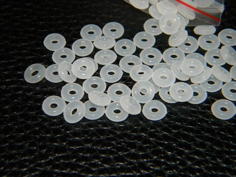 May include: A large quantity of white plastic spacer beads. The beads are round with a hole in the centre.