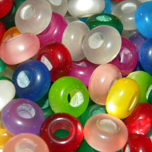 May include: A collection of round, smooth, translucent beads in a variety of vibrant colors including red, blue, green, yellow, pink, and white. Each bead features a central hole, creating a uniform shape across the assortment of colorful pieces.