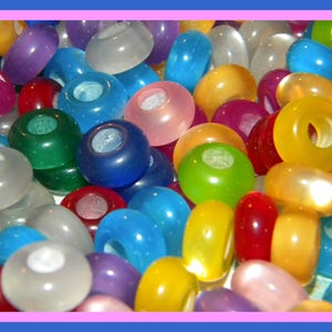 May include: A collection of round, translucent pony beads in a variety of vibrant colors including red, blue, yellow, green, purple, and white. Each bead features a smooth, glossy finish and a central hole, creating a dense, colorful pile.