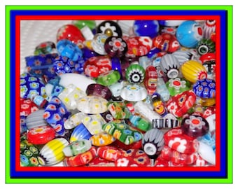 May include: A collection of assorted glass beads in various shapes and sizes, featuring vibrant colors including red, blue, green, yellow, and white. The beads display intricate floral patterns, striped designs, and solid translucent finishes.