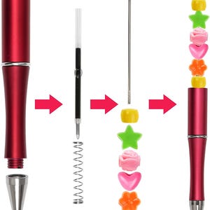 May include: A disassembled red pen with silver accents, showing the components: tip, barrel, ink cartridge, spring, and decorative beads. The beads are yellow, green, pink, and orange, in star, flower, heart, and round shapes. The pen is shown assembled.