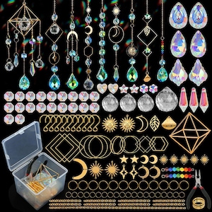 May include: A collection of crystal suncatchers, beads, and metal charms in various shapes, including moons, stars, and geometric designs. The image also includes a clear plastic container with tools and additional components, all set against a black background.