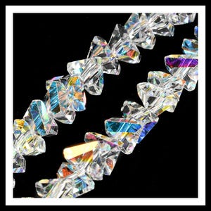 May include: A strand of iridescent clear crystal beads in a triangular shape. The beads are strung together on a clear thread.