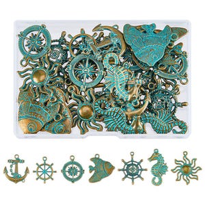 May include: A collection of assorted metal charms in a clear plastic box. The charms are in shades of gold and turquoise and feature nautical and nature-inspired designs, including anchors, seahorses, sunbursts, and compass roses.