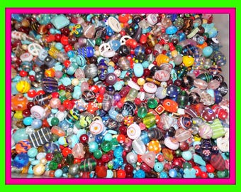 Puede incluir: Un vibrante surtido de cuentas de colores en varias formas y tamaños. Las cuentas son una mezcla de vidrio, cerámica y otros materiales, con una amplia gama de colores, incluyendo rojo, azul, verde y amarillo. Algunas cuentas tienen patrones y diseños intrincados.