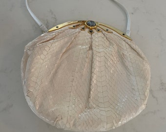 Bolso pequeño vintage de piel de serpiente color crema con estampado de estrella dorada.