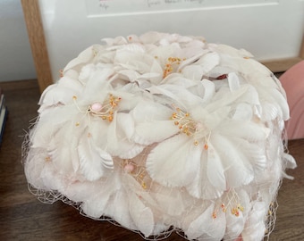 Sombrero tipo pastillero floral rosa claro vintage de los años 50 y 60 con velo tipo jaula.