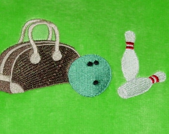 May include: Embroidered bowling-themed design featuring a bowling bag, a green bowling ball with three black holes, and two bowling pins with red stripes. The background is a solid bright green.