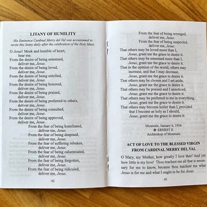 May include: An open booklet displaying the Litany of Humility and an Act of Love to the Blessed Virgin. The white pages feature black printed text, including prayers and religious titles, with page numbers 42 and 43 visible at the bottom.