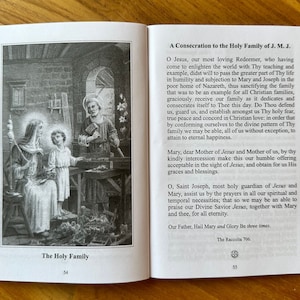 May include: An open book showing pages 54 and 55. Page 54 features a black and white illustration titled The Holy Family, depicting Mary, Jesus, and Joseph in a workshop. Page 55 contains the text A Consecration to the Holy Family of J. M. J.