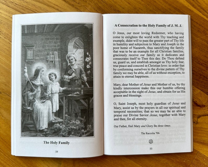 May include: An open book showing pages 54 and 55. Page 54 features a black and white illustration titled The Holy Family, depicting Mary, Jesus, and Joseph in a workshop. Page 55 contains the text A Consecration to the Holy Family of J. M. J.