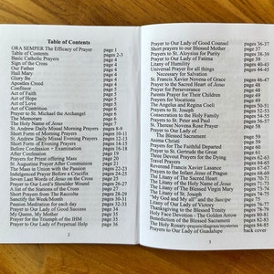 May include: An open prayer book displaying a table of contents on pages two and three. The text lists various Catholic prayers, novenas, and litanies with their corresponding page numbers, printed in black ink on white paper with a clear, readable font.