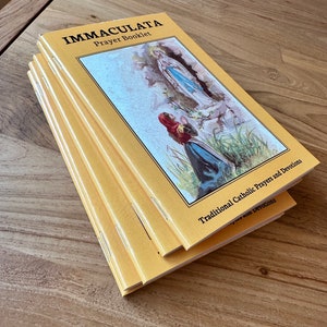 May include: A stack of yellow prayer booklets titled IMMACULATA Prayer Booklet with the subtitle Traditional Catholic Prayers and Devotions. The cover features a color illustration of a figure kneeling before a standing religious figure.