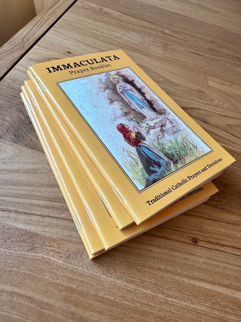 May include: A stack of yellow prayer booklets titled IMMACULATA Prayer Booklet with the subtitle Traditional Catholic Prayers and Devotions. The cover features a color illustration of a figure kneeling before a standing religious figure.