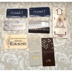 May include: A collection of eight rectangular hotel key cards and room access cards. The cards feature various brand logos and text including Hyatt, Radisson, Omni Rosen Hotel, Omni Berkshire Place Kokachin, The Palace, and VingCard with numbers.