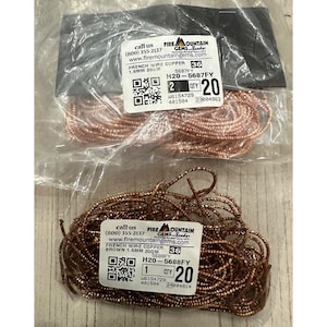 May include: Two packages of French wire copper beads. One package contains copper-colored wire, and the other contains brown wire. Each package has a label with product information, including the wire's diameter and length.