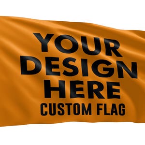 May include: A rectangular orange flag featuring the black text YOUR DESIGN HERE and CUSTOM FLAG. The flag has a white vertical header strip on the left side with two metal grommets for mounting, and the fabric appears to be waving in the wind.